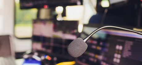 Microphone over the Abstract blurred photo of small conference hall or seminar room with attendee background. Small Business training concept. Public speaking